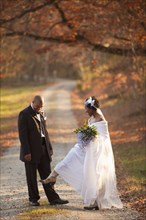 Bride and groom standing on path