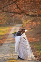 Bride and groom hugging on path