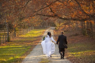 Bride and groom walking on path
