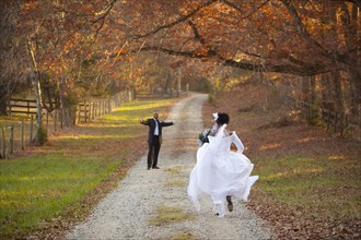 Bride and groom running to each other on path