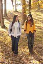 Caucasian teenagers walking together in forest