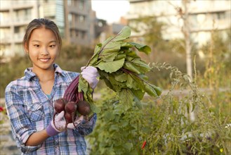 Japanese girl holding bunch of beets