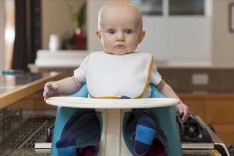 Caucasian baby sitting in high chair