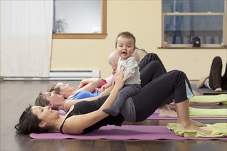 Mothers and babies taking yoga class