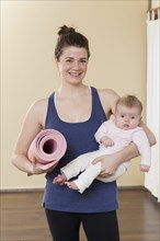 Caucasian mother holding baby in yoga studio