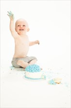 Caucasian baby boy playing with cake