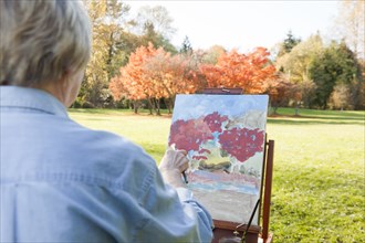 Senior woman painting outdoors