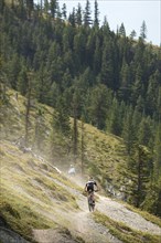 Caucasian woman riding bicycle on remote trail