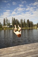 Caucasian boy jumping into lake