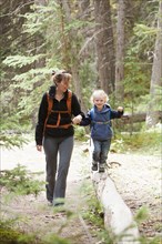 Caucasian mother and son hiking in forest