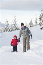 Caucasian mother and son walking in snow