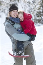 Caucasian mother and son snowshoeing