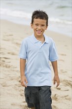 Mixed race boy walking on beach