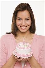 Hispanic woman holding birthday cake