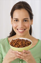 Hispanic woman holding bowl of almonds