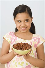 Hispanic girl holding bowl of almonds