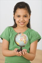Hispanic girl holding small globe