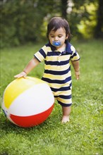 Hispanic baby boy playing with ball
