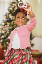 African girl taking self-portrait at Christmas
