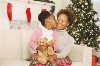 African girl kissing mother at Christmas