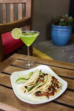 Tacos on plate with margarita