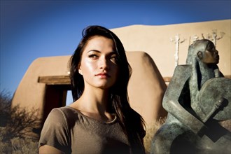 Portrait of Hispanic teenage girl near statue