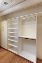 Cabinets and empty shelves in walk-in closet