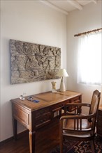 Sculpture on wall above desk and chair