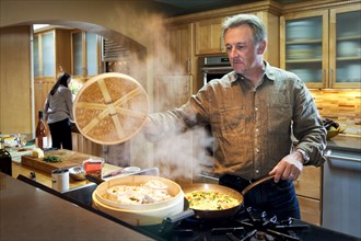 Caucasian man steaming food on stove