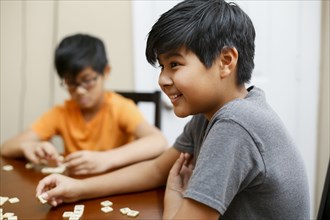 Native American boys playing spelling game at table