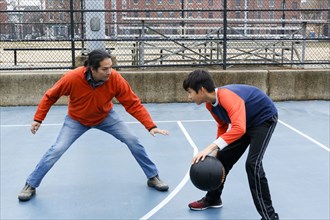 Native American father and son playing basketball