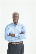 Portrait of smiling older Black man with arms crossed