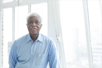 Smiling older Black man near the window