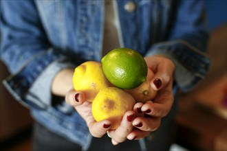 Hands of woman holding lemons and lime