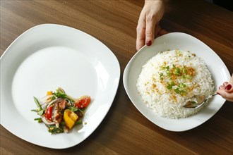 Hands of woman serving rice