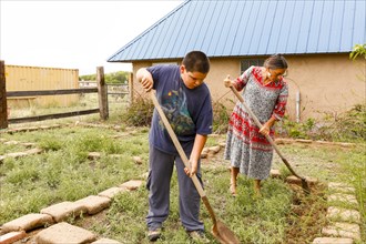 Mother and son shoveling in garden