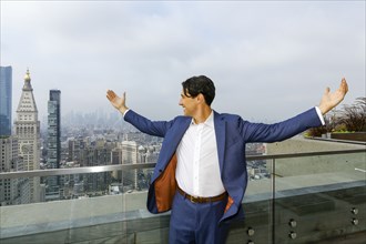 Caucasian businessman celebrating on urban rooftop