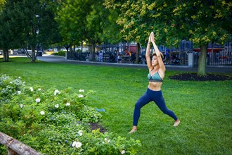 Mixed race woman performing yoga in park