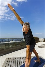 Caucasian man performing yoga on urban rooftop