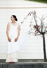 Caucasian woman with wedding dress caught on tree