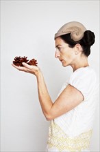 Caucasian woman holding pinecones