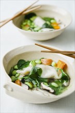 Asian vegetable soup in bowls with chopsticks