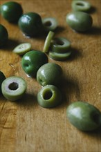 Sliced green olives on cutting board