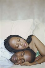 African American couple sleeping on sofa