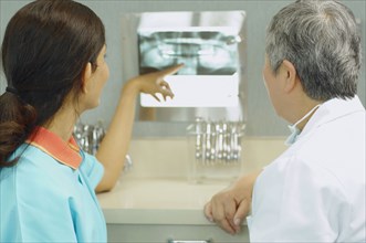 Female dentist and dental assistant looking at x-rays