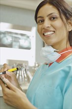 Indian female dental assistant writing on chart