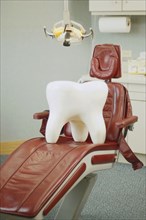Giant tooth sitting on dentist's chair