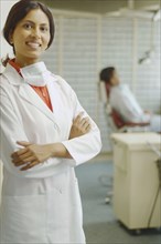 Indian female dentist smiling with patient in background