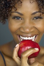 Close up of African woman eating apple