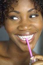 Close up of African woman drinking through straw